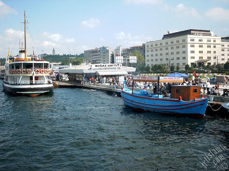 View of Eminonu shore, jetty, ship and fisherman`s boat from the sea in Istanbul city of Turkey.

