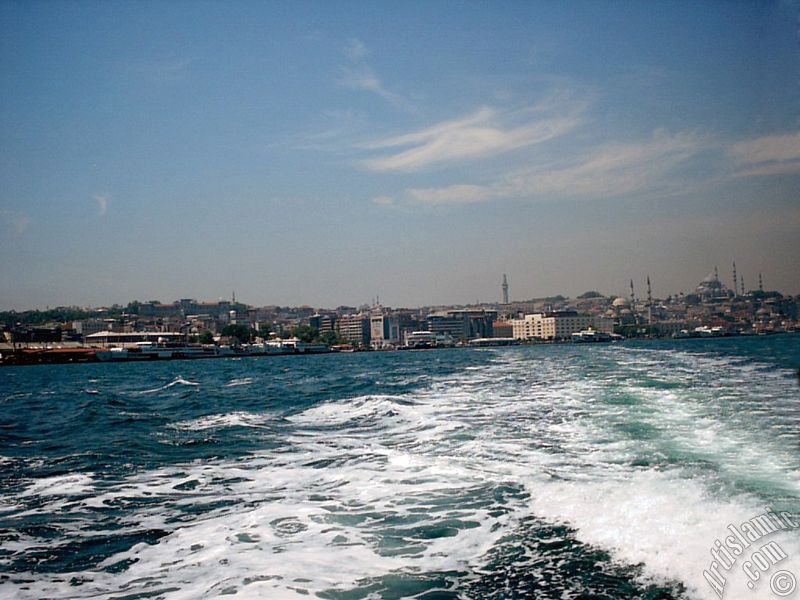 View of Eminonu coast, Beyazit Tower, Yeni Cami (Mosque) and Suleymaniye Mosque from the sea in Istanbul city of Turkey.

