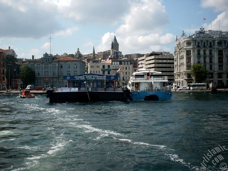 View of the sea bus landed the jetty and at behind above historical Galata Tower from the shore of Karakoy in Istanbul city of Turkey.
