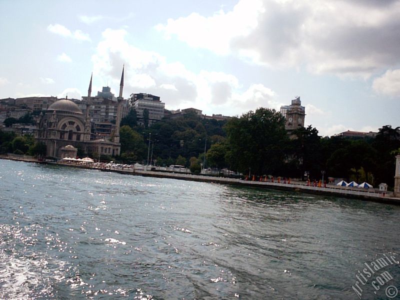 View of Dolmabahce coast, Valide Sultan Mosque and clock tower from the Bosphorus in Istanbul city of Turkey.
