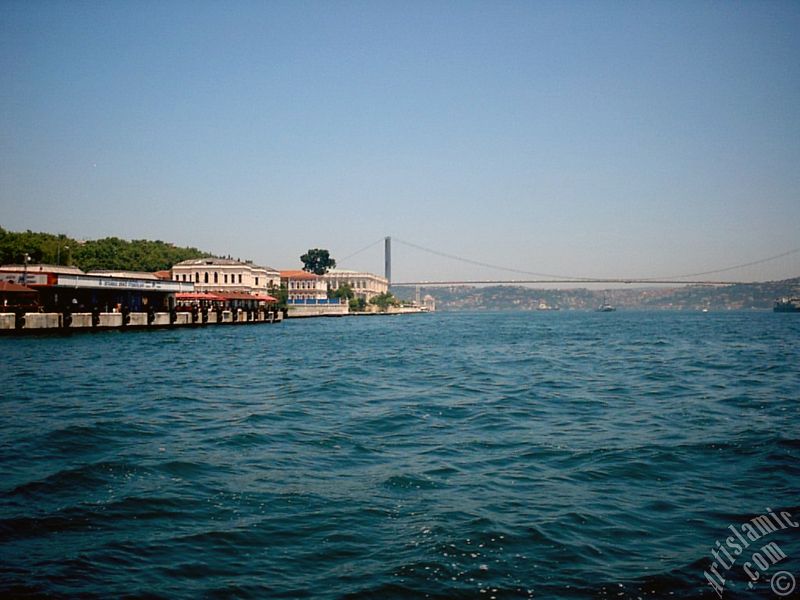 View of the Ciragan Palace and the Bosphorus Bridge from the shore of Besiktas district of Istanbul city in Turkey.
