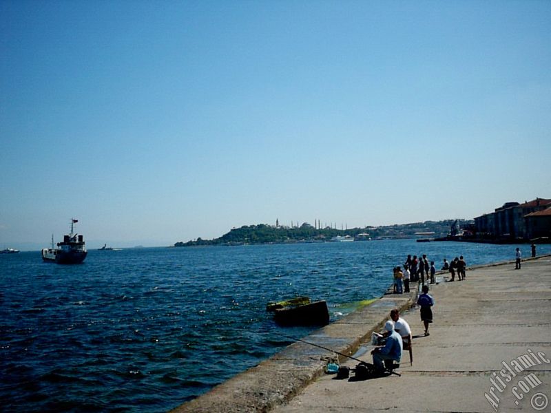 View of fishing people, Sarayburnu coast, Topkapi Palace, Ayasofya Mosque (Hagia Sophia) and Sultan Ahmet Mosque (Blue Mosque) from a park at Kabatas shore in Istanbul city of Turkey.
