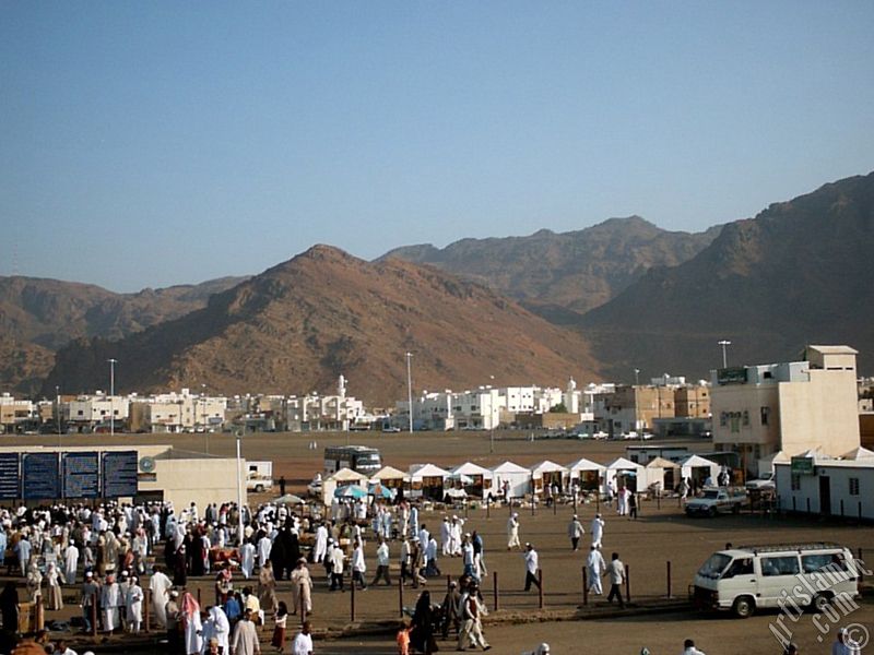 The Mounts Uhud, the field of Battle of Uhud (the second battle of the Prophet Muhammad [saaw] against unbelievers); the cemetery of the first muslims died for Islam during the Battle of Uhud (located in the left) and the pilgrims visiting these places in Mecca city of Saudi Arabia.
